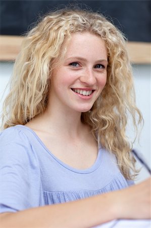 simsearch:400-04841324,k - Smiling blonde teenager doing homework in a library Photographie de stock - Aubaine LD & Abonnement, Code: 400-04199255