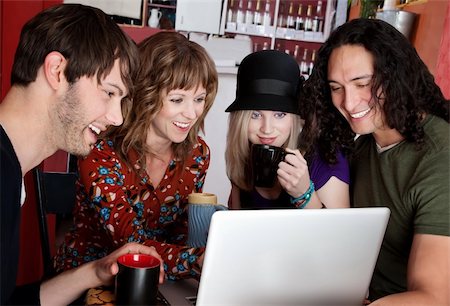 Four friends laughing at content on a laptop Stock Photo - Budget Royalty-Free & Subscription, Code: 400-04199622