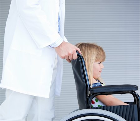 simsearch:400-05147195,k - Smiling little girl sitting on the wheelchair supported by a doctor at the hospital Stock Photo - Budget Royalty-Free & Subscription, Code: 400-04190158