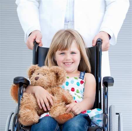 simsearch:400-05147195,k - Portrait of a little girl sitting on the wheelchair supported by a male doctor at the hospital Stock Photo - Budget Royalty-Free & Subscription, Code: 400-04190180