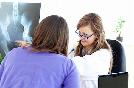 simsearch:400-08751444,k - Delighted female doctor pointing an x-ray with her patient Photographie de stock - Aubaine LD & Abonnement, Code: 400-04190196