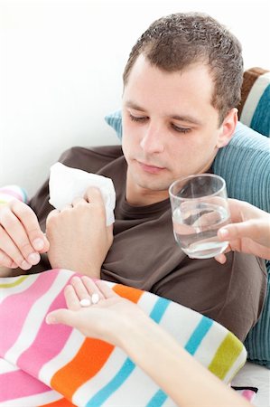 simsearch:400-04201129,k - Sick man taking medicine on the sofa at home Stock Photo - Budget Royalty-Free & Subscription, Code: 400-04190819