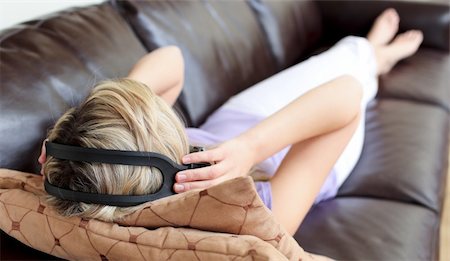 simsearch:6109-06194973,k - Beautiful woman using headphones on a sofa Foto de stock - Super Valor sin royalties y Suscripción, Código: 400-04190952