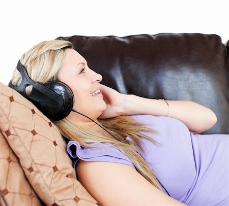 simsearch:6109-06194973,k - Relaxed woman using headphones on a sofa Foto de stock - Super Valor sin royalties y Suscripción, Código: 400-04190977