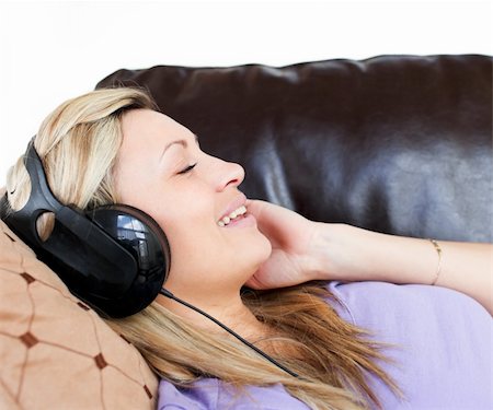 simsearch:6109-06194973,k - Smiling woman using headphones on a sofa Foto de stock - Super Valor sin royalties y Suscripción, Código: 400-04191746