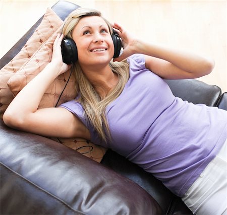 simsearch:6109-06194965,k - Happy woman using headphones on a sofa Foto de stock - Super Valor sin royalties y Suscripción, Código: 400-04191779