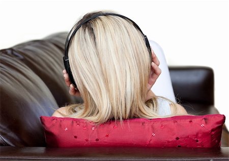 simsearch:6109-06194965,k - Young woman using headphones on a sofa Foto de stock - Super Valor sin royalties y Suscripción, Código: 400-04191772