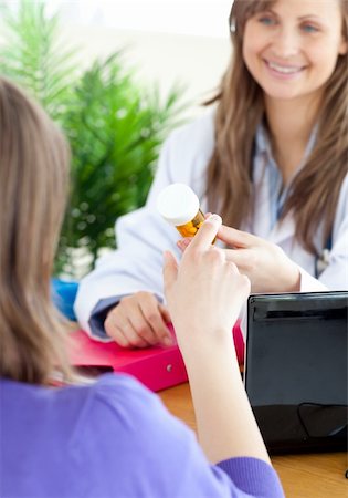 Close-up of a beautiful female doctor holding medicine in her office Stock Photo - Budget Royalty-Free & Subscription, Code: 400-04191878