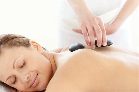 simsearch:400-04192063,k - Portrait of a radiant woman having a massage with stones at the spa Fotografie stock - Microstock e Abbonamento, Codice: 400-04192101