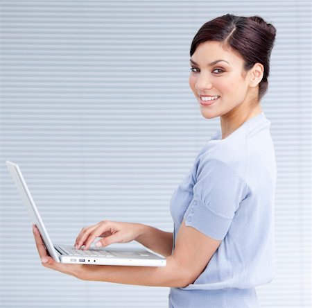simsearch:400-04187842,k - Cheerful businesswoman using a laptop at work Stock Photo - Budget Royalty-Free & Subscription, Code: 400-04192327