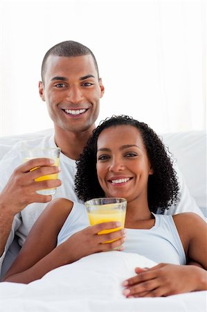 simsearch:400-04326193,k - Enamored couple drinking orange juice lying on their bed Stock Photo - Budget Royalty-Free & Subscription, Code: 400-04192357