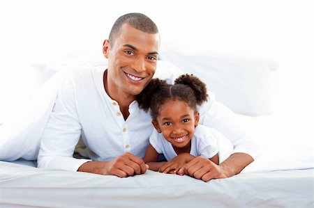 simsearch:400-04193152,k - Caring father and his daughter lying on a bed smiling at the camera Stockbilder - Microstock & Abonnement, Bildnummer: 400-04192367