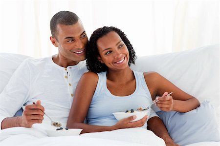 Cheerful couple having breakfast lying on their bed Stock Photo - Budget Royalty-Free & Subscription, Code: 400-04192361
