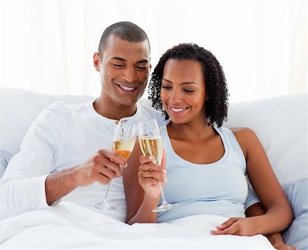Cheerful couple toasting with Champagne lying on their bed Photographie de stock - Aubaine LD & Abonnement, Code: 400-04192362