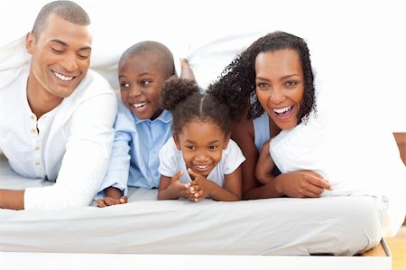 simsearch:400-04193152,k - Portrait of a attentive parents with their children playing on a bed Stockbilder - Microstock & Abonnement, Bildnummer: 400-04192425