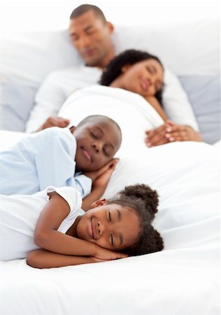 simsearch:400-04192370,k - Jolly family sleeping lying on a bed Fotografie stock - Microstock e Abbonamento, Codice: 400-04192446