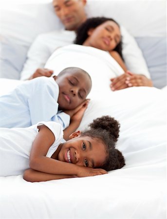Happy family having fun lying on a bed Stock Photo - Budget Royalty-Free & Subscription, Code: 400-04192447