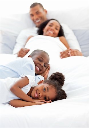 simsearch:400-04192370,k - Smiling family having fun lying on a bed Fotografie stock - Microstock e Abbonamento, Codice: 400-04192449