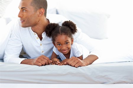 Father and his daughter having fun lying on a bed Stock Photo - Budget Royalty-Free & Subscription, Code: 400-04192443