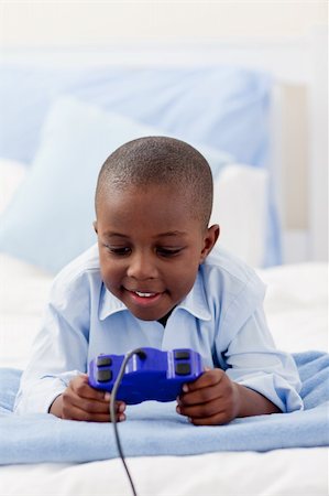 simsearch:400-04200279,k - Little boy playing video game lying on a bed Stock Photo - Budget Royalty-Free & Subscription, Code: 400-04192464