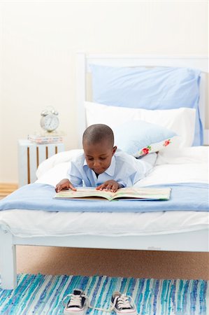 simsearch:400-05751566,k - Little boy reading a book lying on his bed Stock Photo - Budget Royalty-Free & Subscription, Code: 400-04192467
