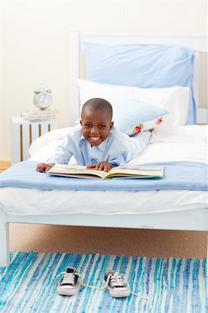 simsearch:400-05751566,k - Smiling little boy reading a book lying on his bed Stock Photo - Budget Royalty-Free & Subscription, Code: 400-04192468