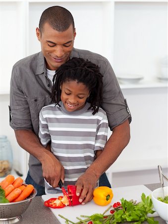 Attentive father helping his son cut vegetables in the kitchen Stock Photo - Budget Royalty-Free & Subscription, Code: 400-04192491
