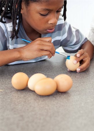 Cute Afro-american little boy painting eggs in the kitchen Stock Photo - Budget Royalty-Free & Subscription, Code: 400-04192502