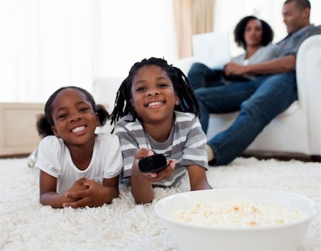 Little siblings watching television and eating pop corn in the living room Stock Photo - Budget Royalty-Free & Subscription, Code: 400-04192525