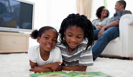 Cute siblings reading lying on the floor in the living room Stock Photo - Budget Royalty-Free & Subscription, Code: 400-04192531