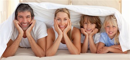 simsearch:400-04193152,k - Portrait of a attentive parents with their children playing on a bed Stockbilder - Microstock & Abonnement, Bildnummer: 400-04192543