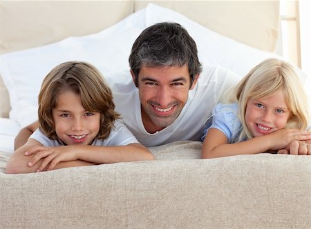 simsearch:400-04193152,k - Caring father and his children lying on a bed at home Stockbilder - Microstock & Abonnement, Bildnummer: 400-04192550