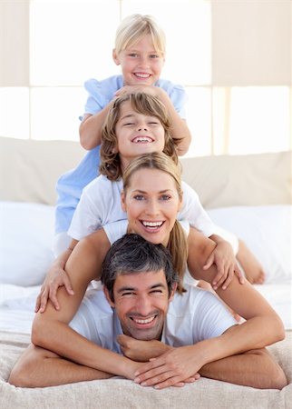 simsearch:400-04193152,k - Happy family having fun on a bed at home Stockbilder - Microstock & Abonnement, Bildnummer: 400-04192551