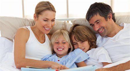 simsearch:400-04192370,k - Joyful family reading a book  lying on bed Stock Photo - Budget Royalty-Free & Subscription, Code: 400-04193050