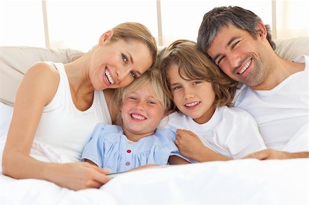 simsearch:400-04192370,k - Happy family reading a book  lying in bed Fotografie stock - Microstock e Abbonamento, Codice: 400-04193066
