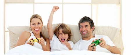 simsearch:400-04199147,k - Smiling little boy playing video game with his family in the bedroom Foto de stock - Royalty-Free Super Valor e Assinatura, Número: 400-04193062