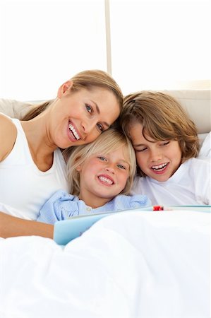 simsearch:400-04193152,k - Beautiful mother and her children reading book lying in bed Stockbilder - Microstock & Abonnement, Bildnummer: 400-04193078