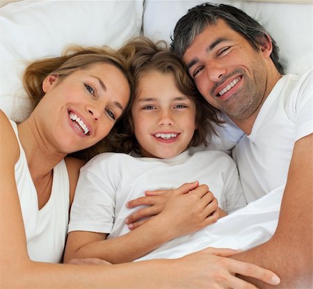 simsearch:400-04192370,k - Happy family lying together on bed Fotografie stock - Microstock e Abbonamento, Codice: 400-04193093