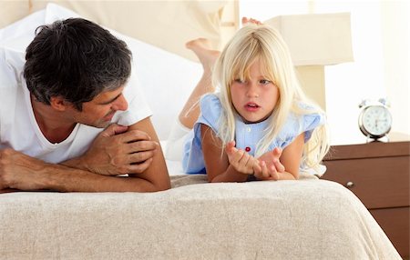 father daughter sad hug - Little girl talking seriously with her father lying on bed Stock Photo - Budget Royalty-Free & Subscription, Code: 400-04193117