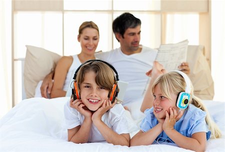 Brother and sister listening music with headphones lying on bed Stock Photo - Budget Royalty-Free & Subscription, Code: 400-04193126