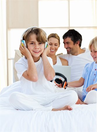 simsearch:400-04200290,k - Happy little boy listening music sitting on bed at home Stock Photo - Budget Royalty-Free & Subscription, Code: 400-04193121