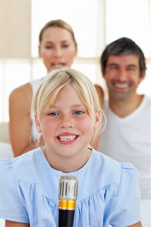 simsearch:400-04157519,k - Cute little girl singing with a microphone sitting on her parent's bed Stock Photo - Budget Royalty-Free & Subscription, Code: 400-04193134