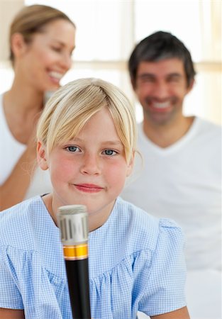 simsearch:400-04157521,k - Blond child singing with a microphone sitting on her parent's bed Stock Photo - Budget Royalty-Free & Subscription, Code: 400-04193135