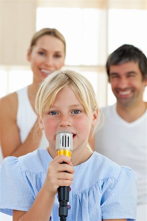 simsearch:400-04157519,k - Adorable little girl singing with a microphone sitting on her parent's bed Stock Photo - Budget Royalty-Free & Subscription, Code: 400-04193136