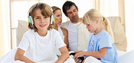 Smiling siblings listening music with headphones at home Stock Photo - Budget Royalty-Free & Subscription, Code: 400-04193131