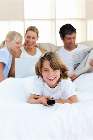 Enthusiastic little boy holding a remote  lying on the bed Stock Photo - Budget Royalty-Free & Subscription, Code: 400-04193145