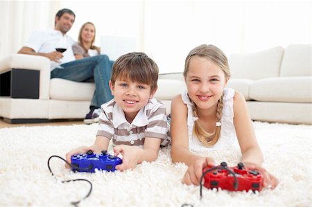 simsearch:400-04199147,k - Brother and sister playing video games lying on the floor Foto de stock - Royalty-Free Super Valor e Assinatura, Número: 400-04193267