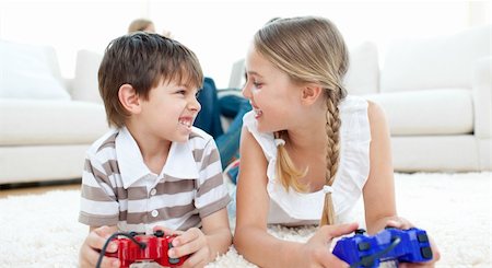 simsearch:400-05315413,k - Close-up of children playing video games lying on the floor Fotografie stock - Microstock e Abbonamento, Codice: 400-04193260