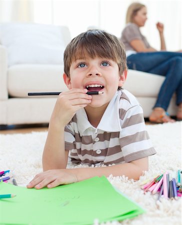 simsearch:400-04195267,k - Close-up of little boy drawing lying on the floor in the living room Photographie de stock - Aubaine LD & Abonnement, Code: 400-04193277