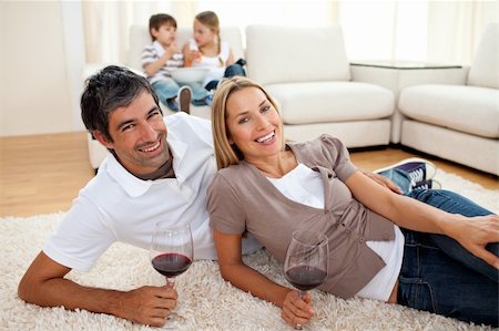 simsearch:400-04663577,k - Affectionate lovers drinking wine lying on the floor in the living room Stock Photo - Budget Royalty-Free & Subscription, Code: 400-04193284